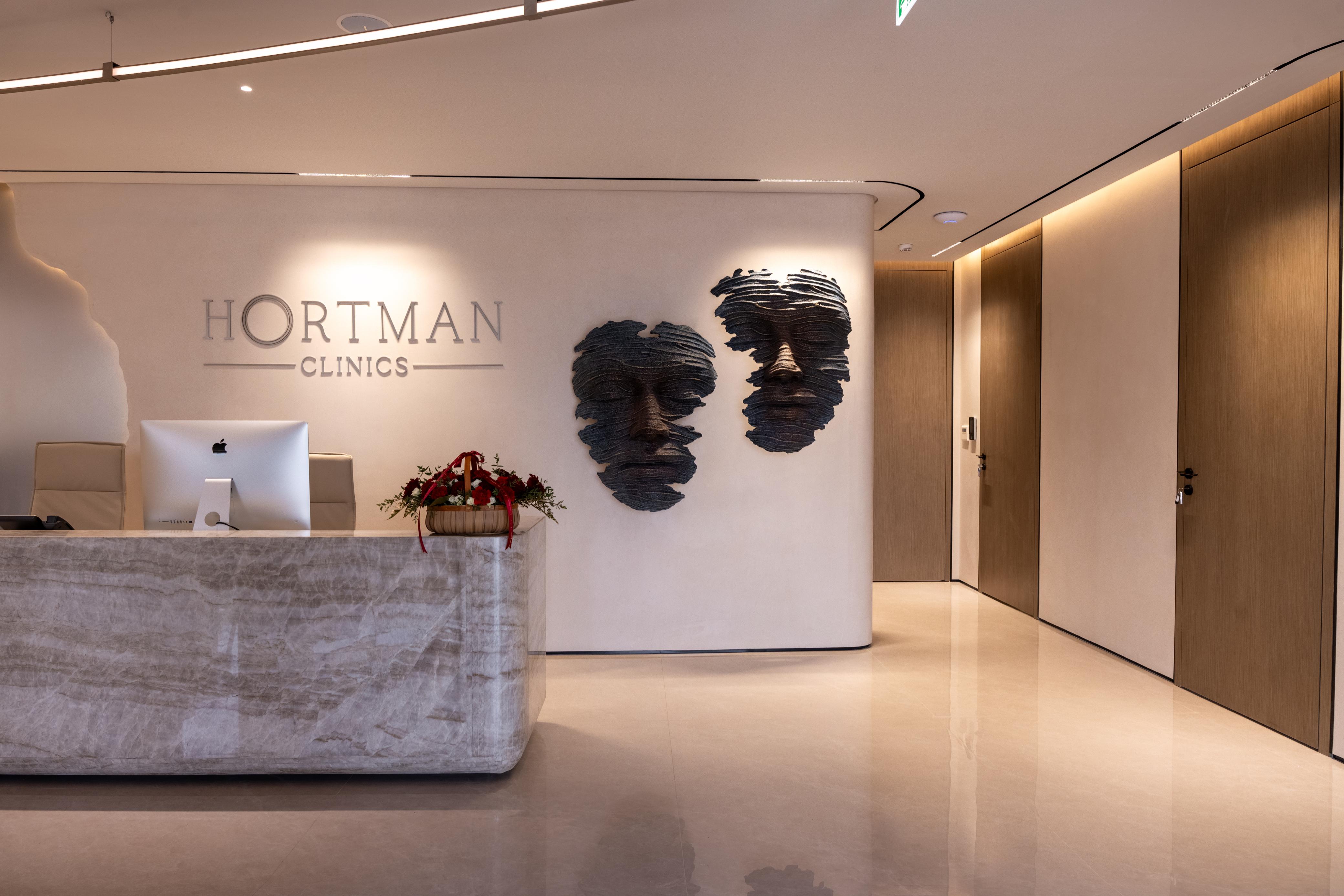 Reception at Hortman Clinics Jumeirah 3, marble desk and sculpted faces on the wall
